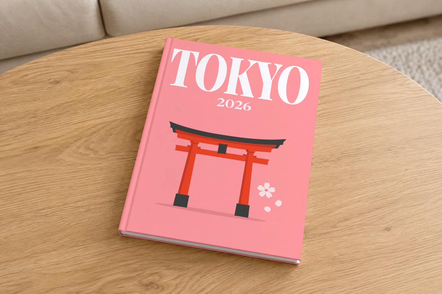 Japan hardcover photo book with the Tokyo illustrated cover of a red torii gate and petals on pink, on a round oak coffee table in a bright living room