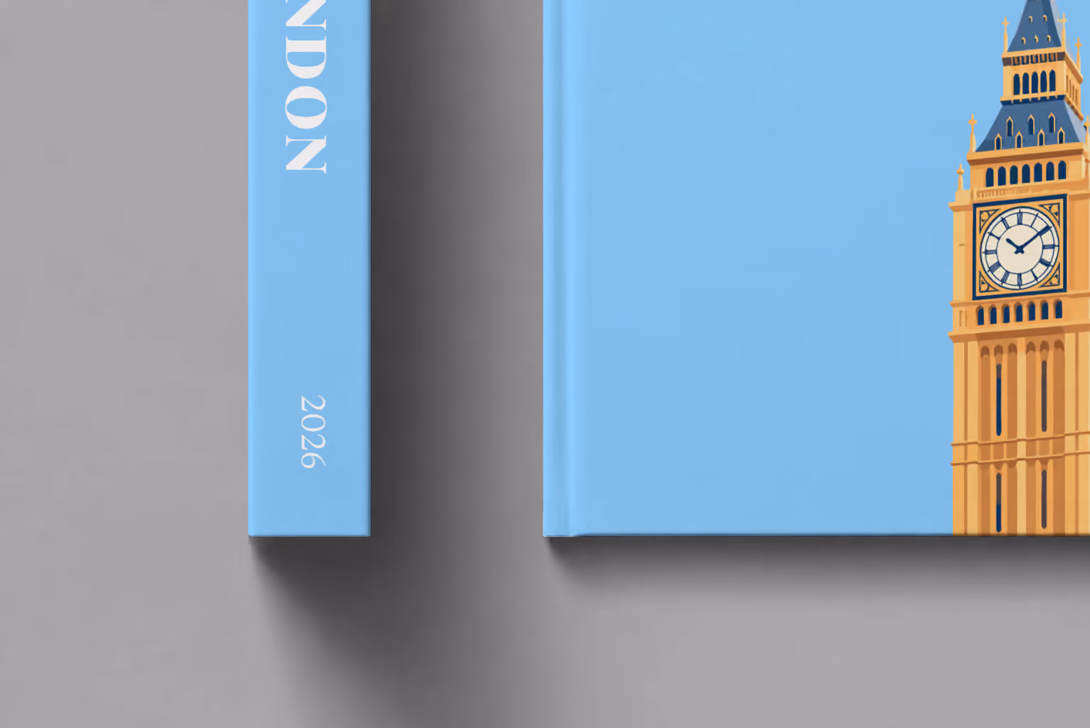 London hardcover photo book with the illustrated cover of Big Ben's Elizabeth Tower on sky blue, shown close up beside its spine on a pale grey studio surface