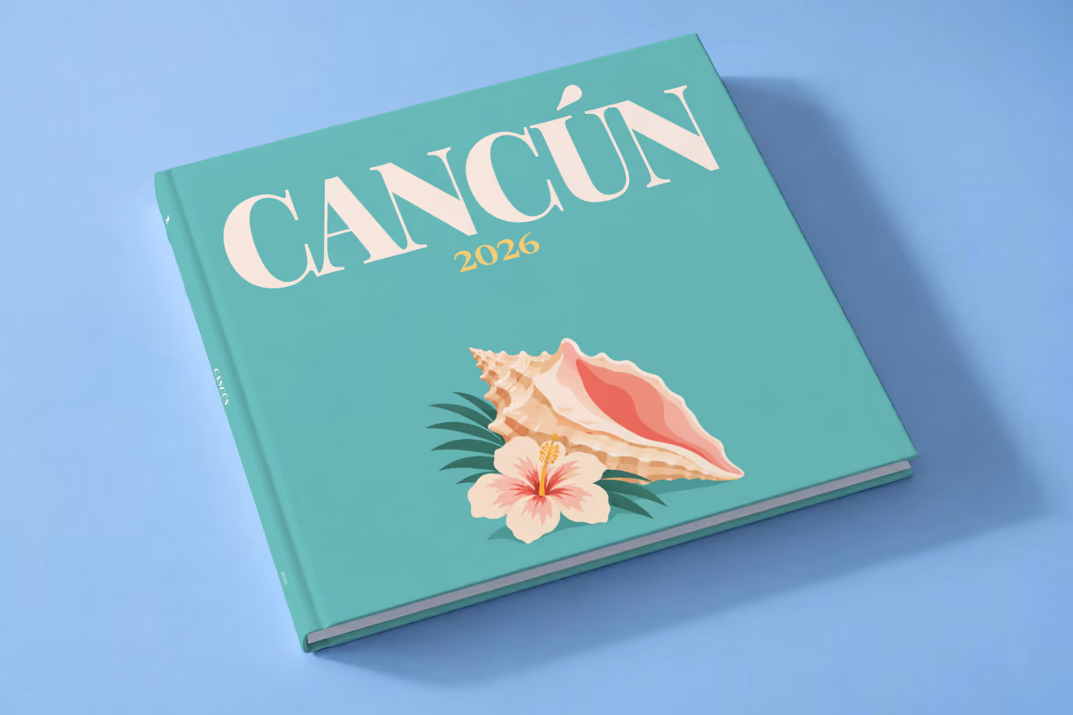 Mexico square hardcover photo book with the Cancún illustrated cover of a conch shell and hibiscus on teal, lying on a pale blue studio backdrop