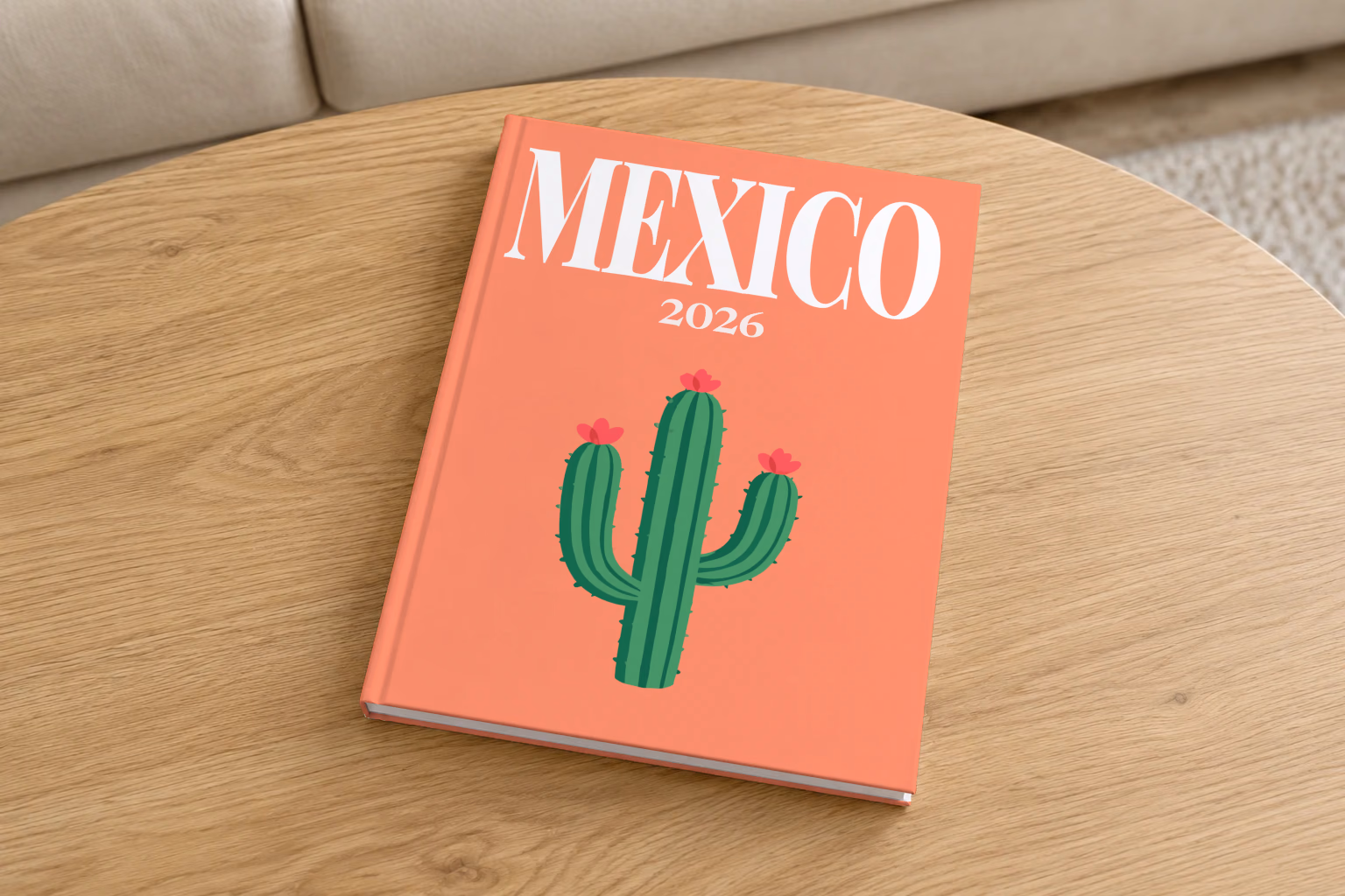 Mexico hardcover photo book with the illustrated cover of a flowering cactus on coral, on a round oak coffee table in a bright living room