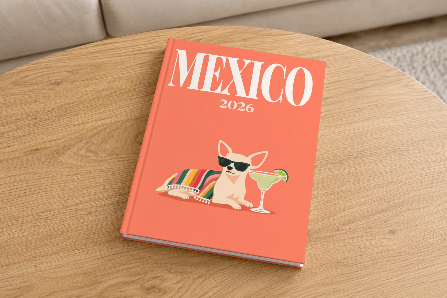 Mexico hardcover photo book with the illustrated cover of a chihuahua in sunglasses with a margarita on coral, on a round oak coffee table in a bright living room