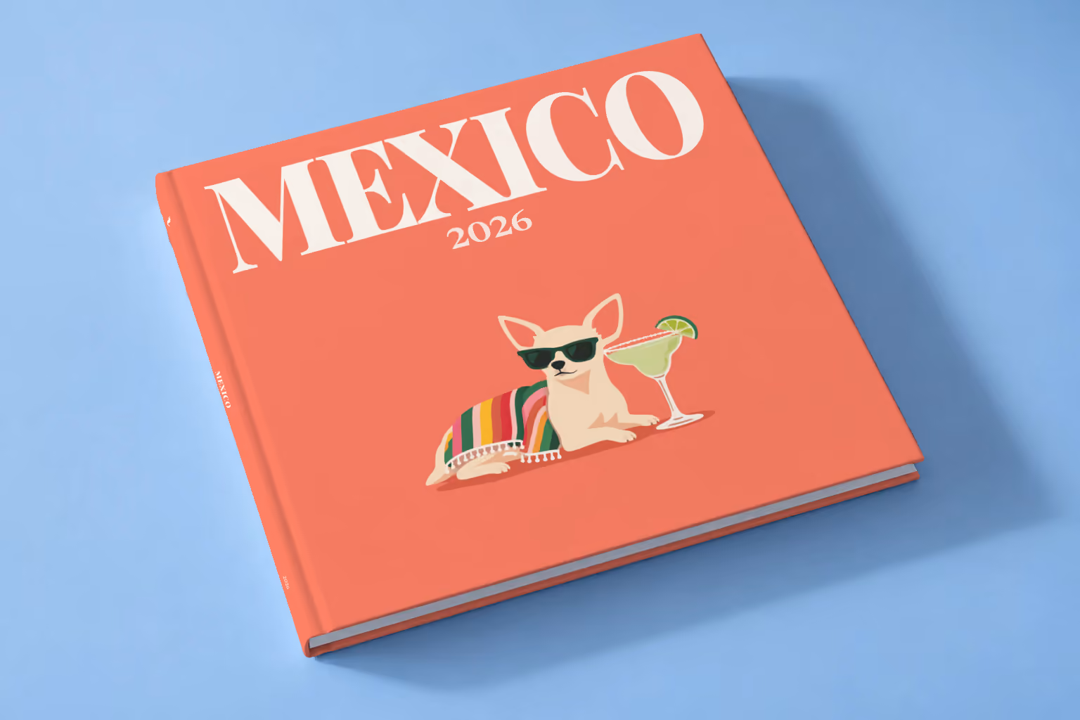Mexico square hardcover photo book with the illustrated cover of a chihuahua in sunglasses with a margarita on coral, lying on a pale blue studio backdrop