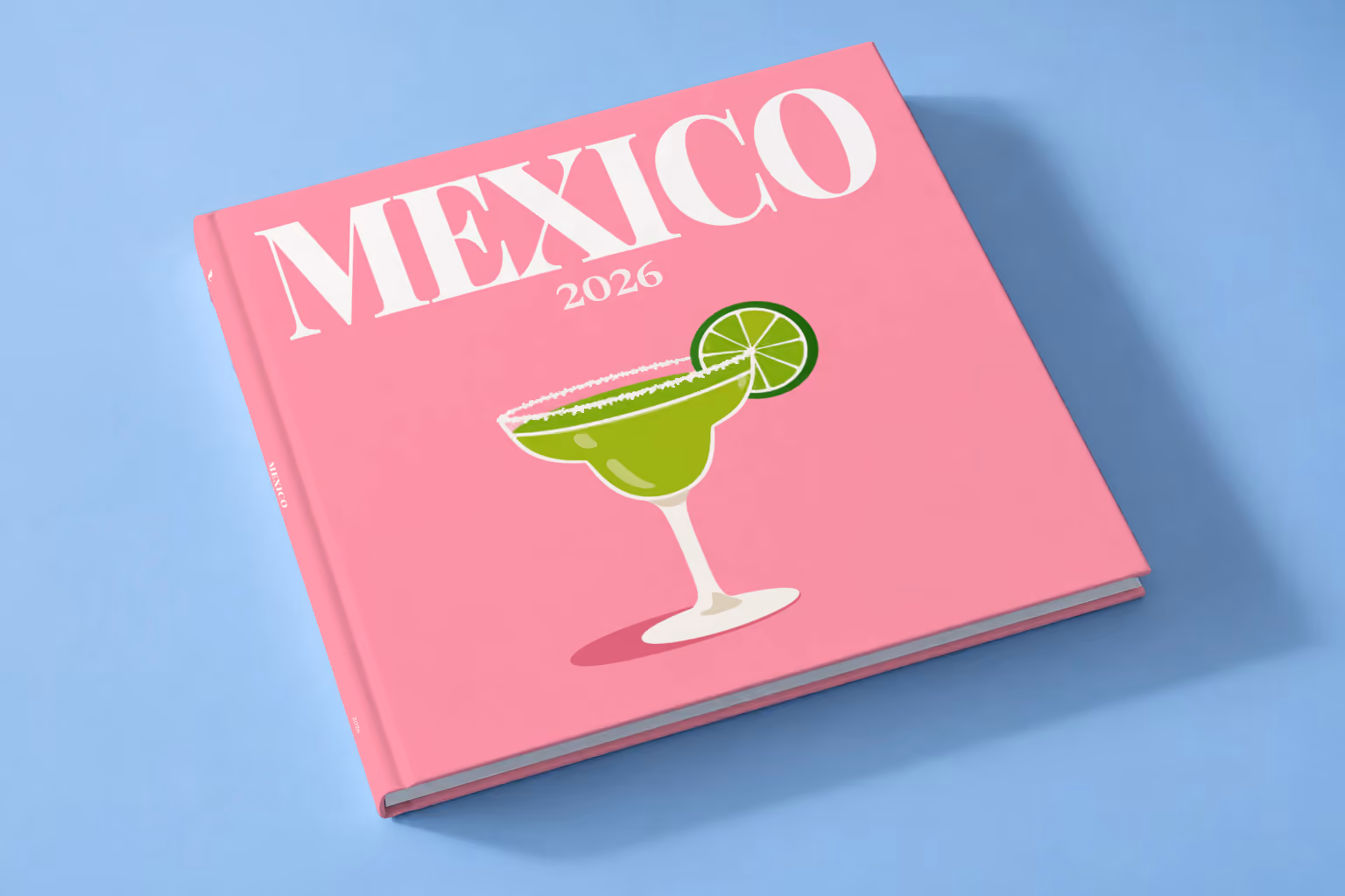 Mexico square hardcover photo book with the illustrated cover of a margarita with lime on pink, lying on a pale blue studio backdrop