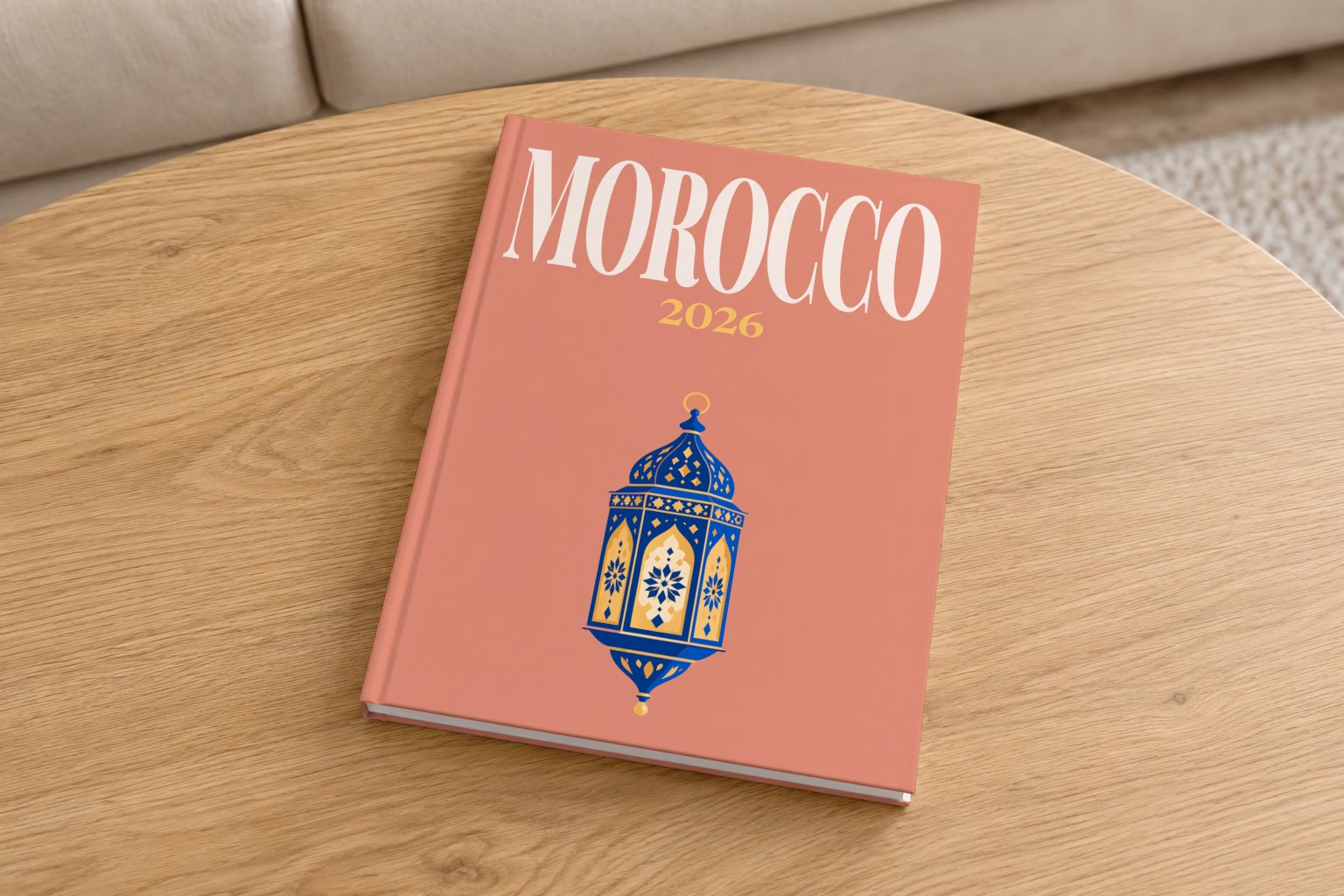 Morocco hardcover photo book with the illustrated cover of a blue and gold Moroccan lantern on dusty terracotta, on a round oak coffee table in a bright living room