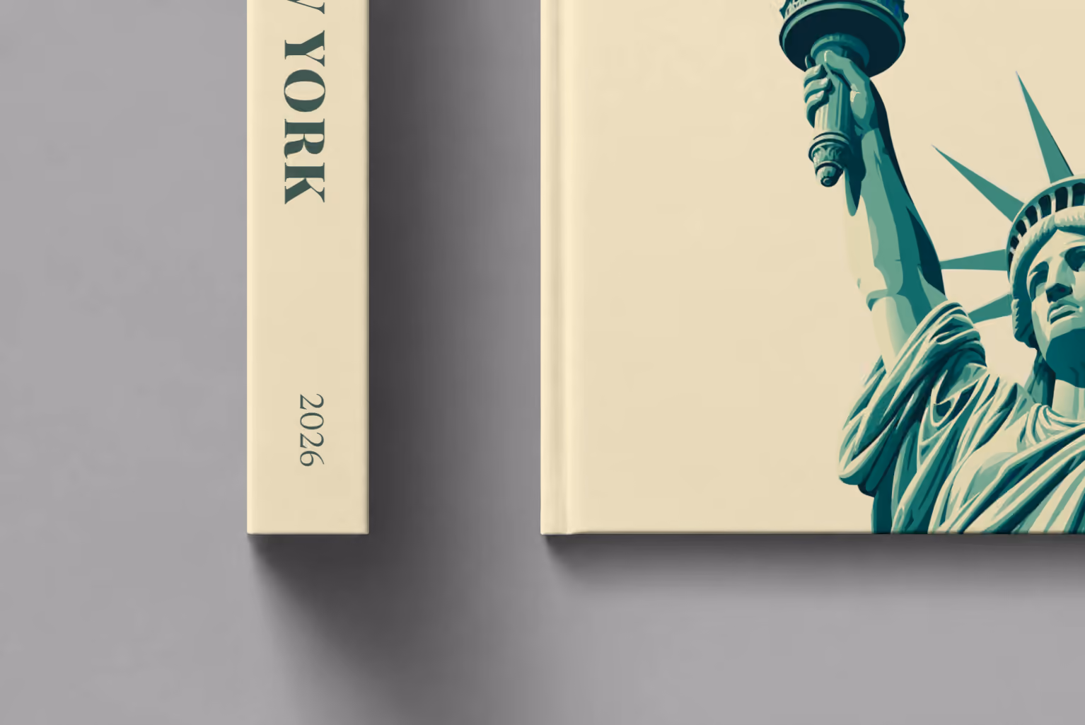 New York hardcover photo book with the illustrated cover of the Statue of Liberty on cream, shown close up beside its spine on a pale grey studio surface