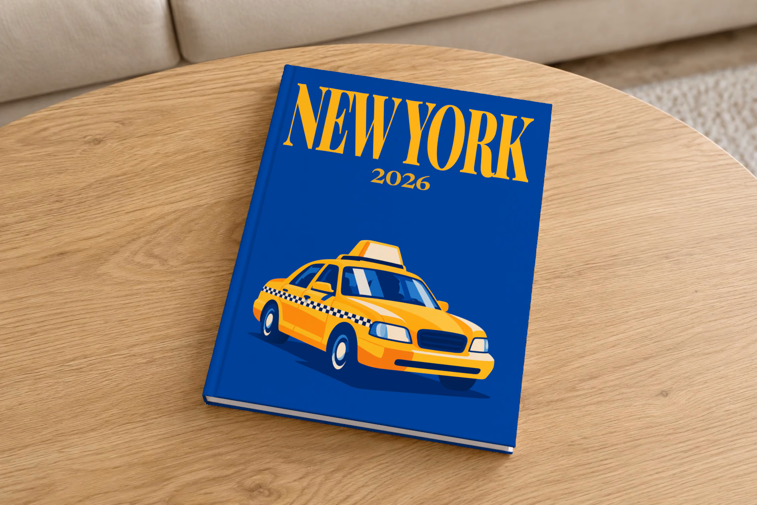 New York hardcover photo book with the illustrated cover of a yellow taxi on royal blue, on a round oak coffee table in a bright living room