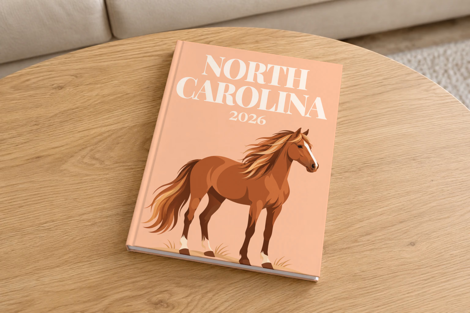 North Carolina hardcover photo book with the illustrated cover of a wild Outer Banks horse on peach, on a round oak coffee table in a bright living room