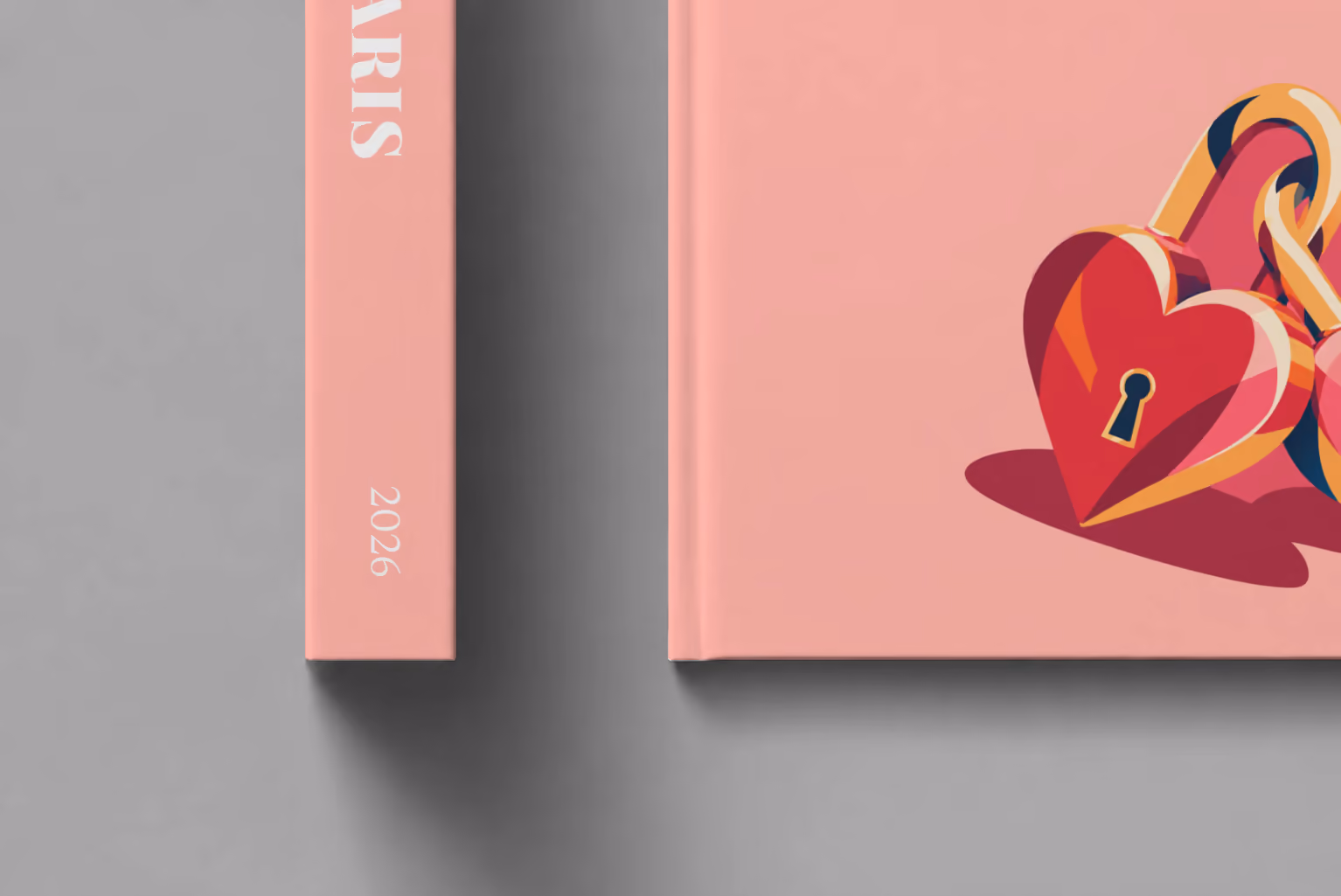 Paris hardcover photo book with the illustrated cover of heart-shaped love locks on salmon pink, shown close up beside its spine on a pale grey studio surface