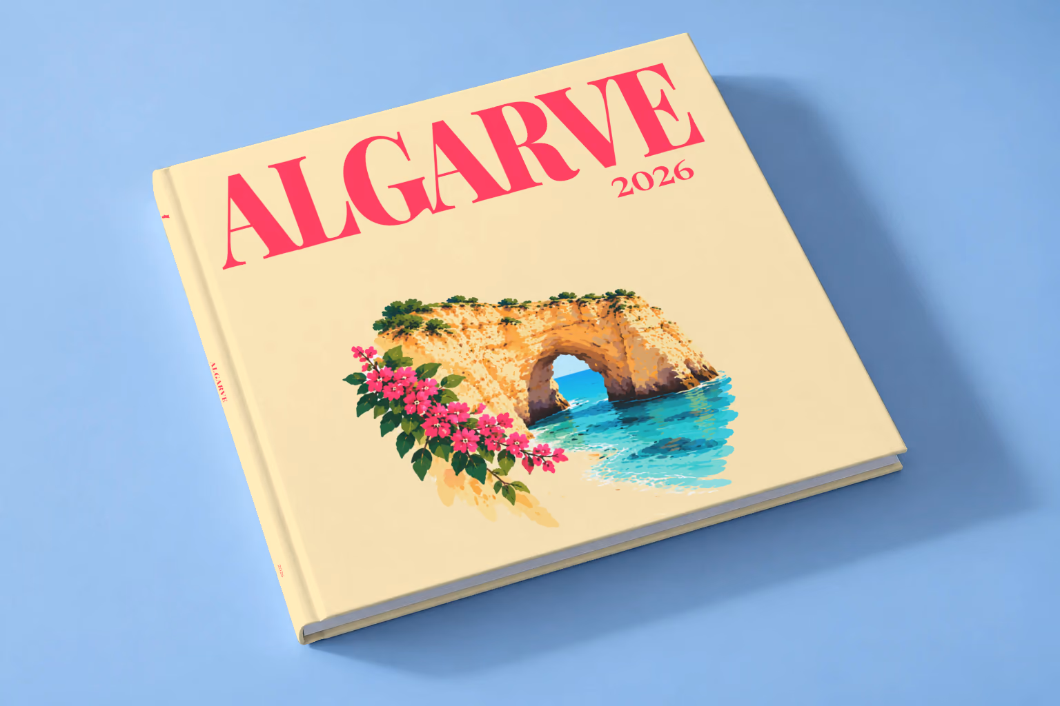Portugal square hardcover photo book with the Algarve illustrated cover of a golden Algarve sea arch over turquoise water with pink bougainvillea on pale yellow, lying on a pale blue studio backdrop
