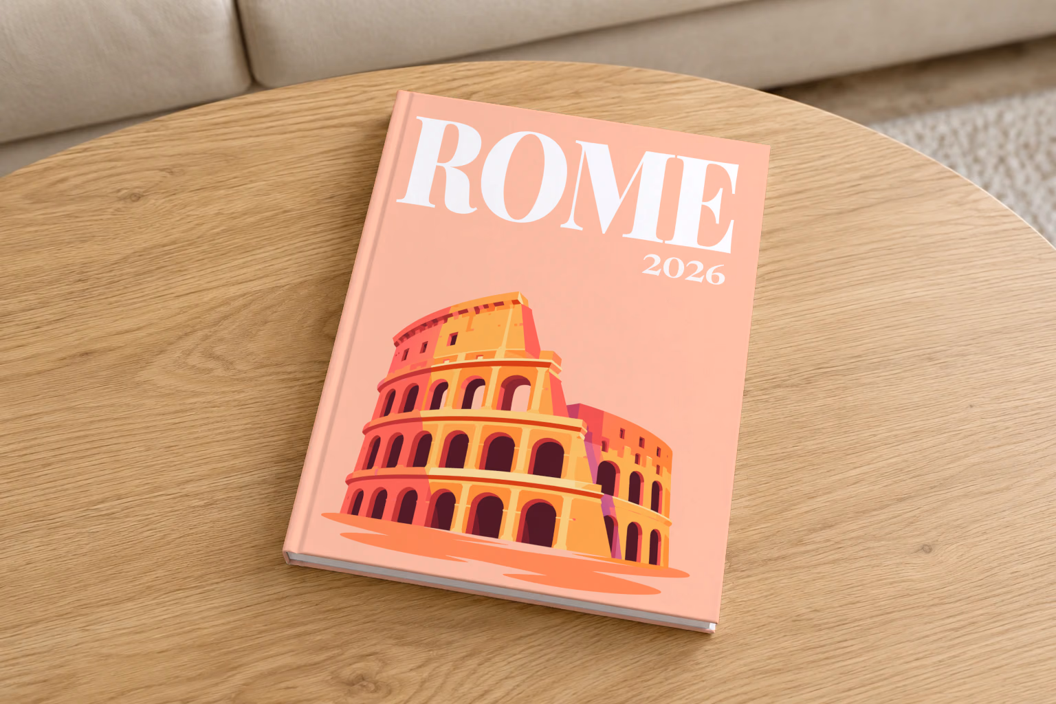 Rome hardcover photo book with the illustrated cover of the Colosseum on peach, on a round oak coffee table in a bright living room