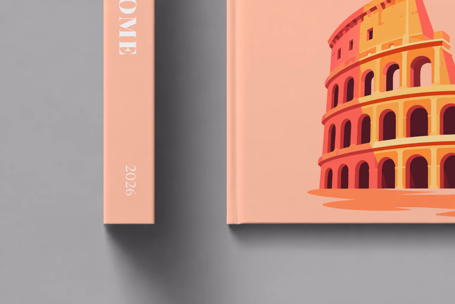 Rome hardcover photo book with the illustrated cover of the Colosseum on peach, shown close up beside its spine on a pale grey studio surface