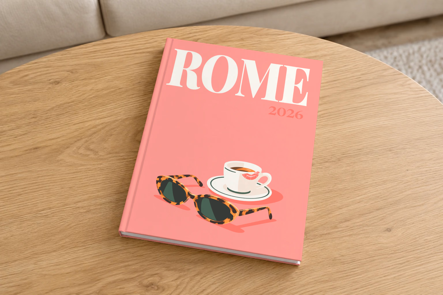 Rome hardcover photo book with the illustrated cover of an espresso cup and tortoiseshell sunglasses on salmon pink, on a round oak coffee table in a bright living room