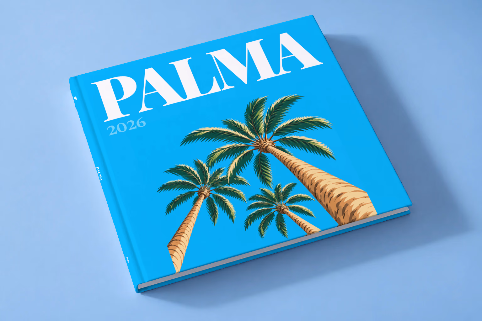 Spain square hardcover photo book with the Palma illustrated cover of palm trees on bright blue, lying on a pale blue studio backdrop