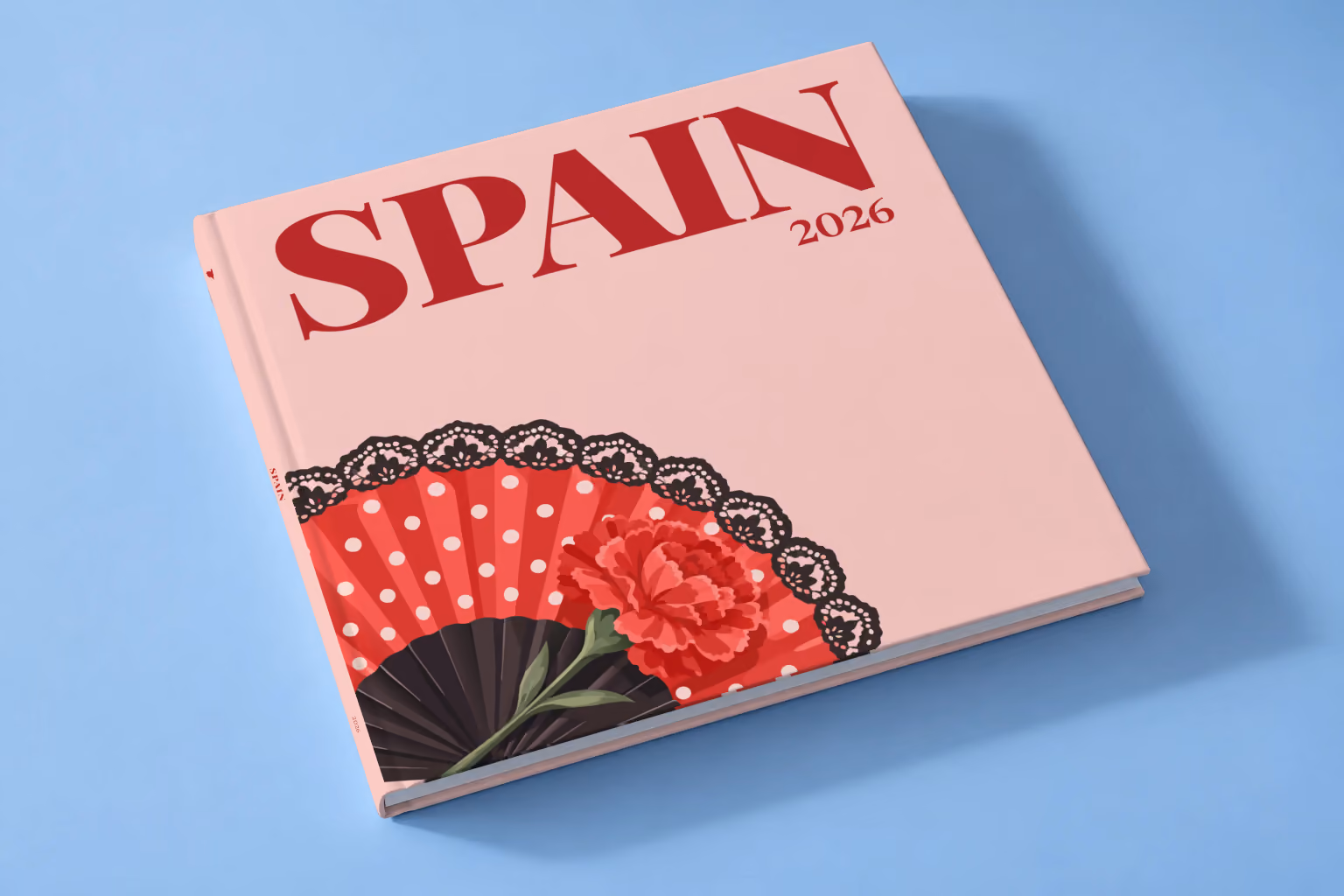Spain square hardcover photo book with the illustrated cover of a polka-dot flamenco fan and a carnation on blush pink, lying on a pale blue studio backdrop