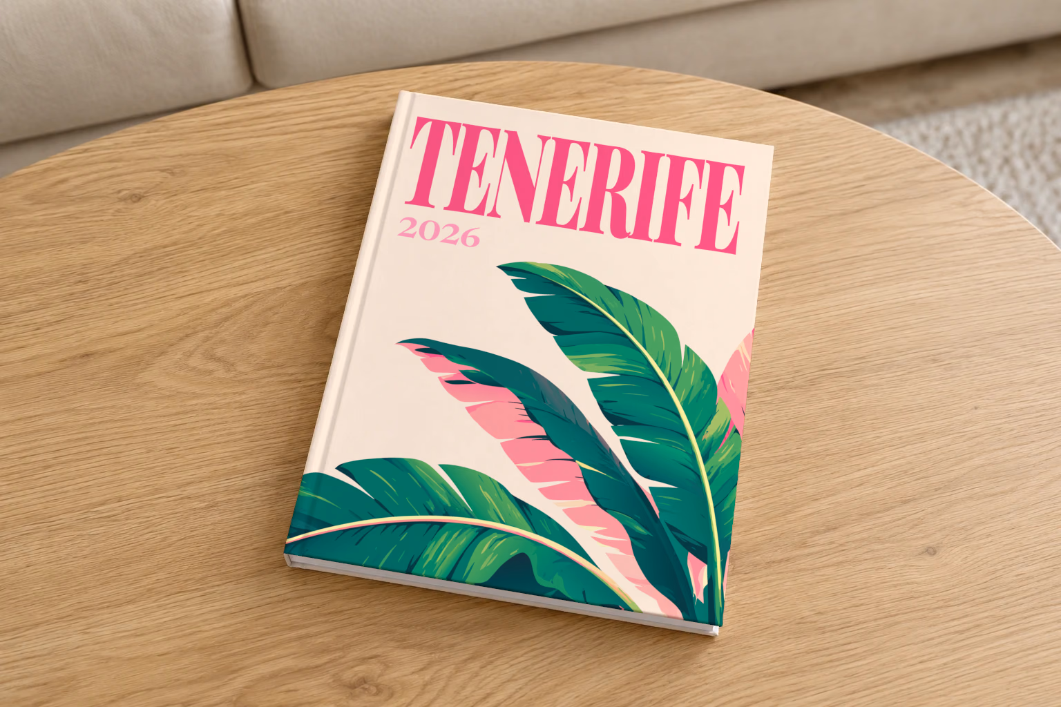 Spain hardcover photo book with the Tenerife illustrated cover of banana leaves on cream, on a round oak coffee table in a bright living room