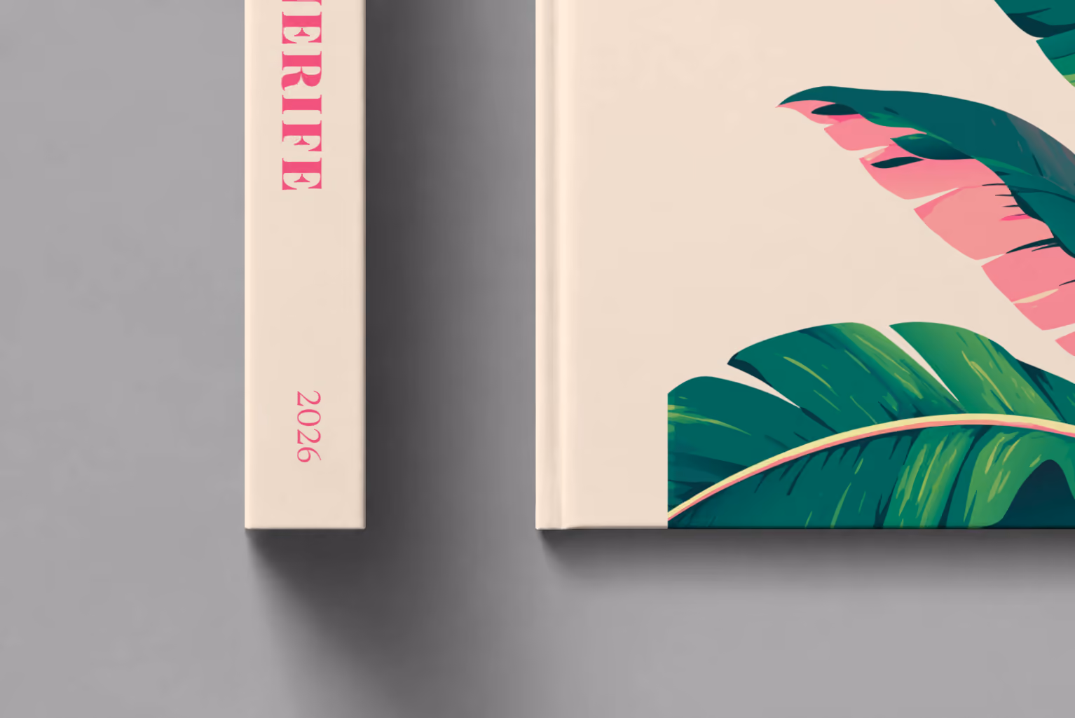 Spain hardcover photo book with the Tenerife illustrated cover of banana leaves on cream, shown close up beside its spine on a pale grey studio surface