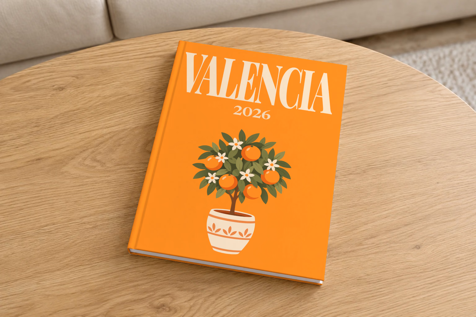 Spain hardcover photo book with the Valencia illustrated cover of a potted orange tree on orange, on a round oak coffee table in a bright living room