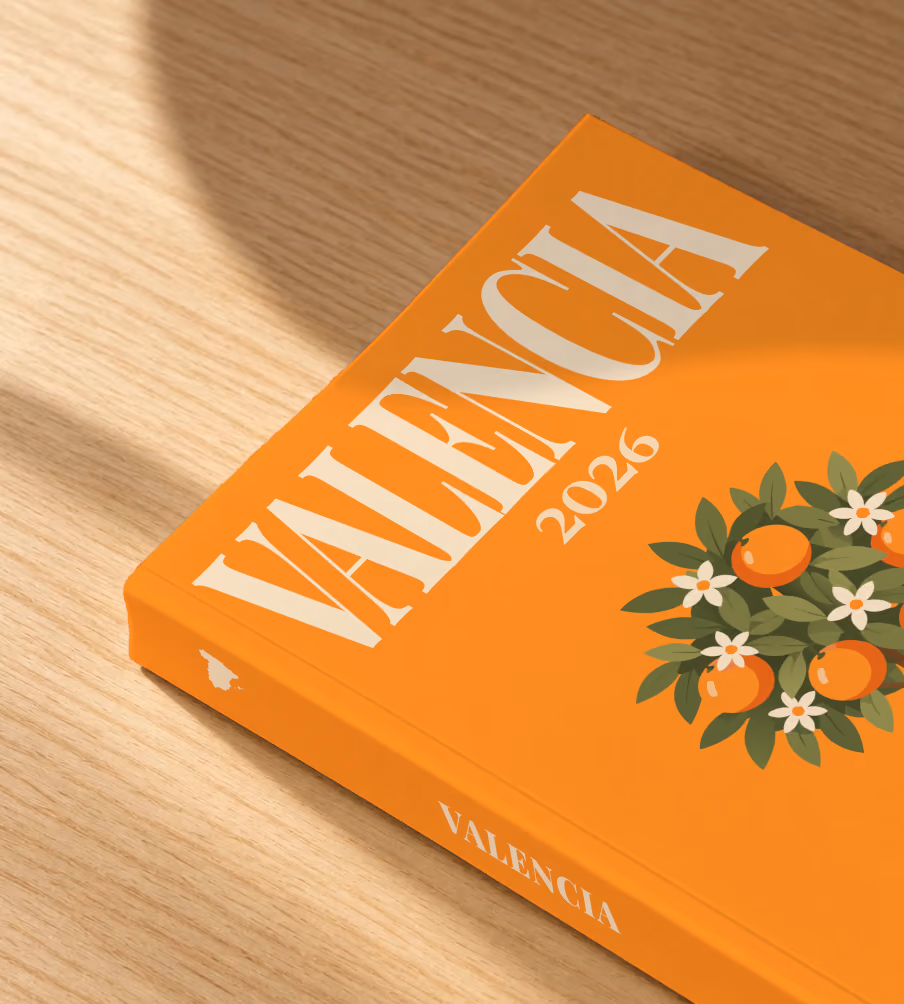 Spain softcover photo book with the Valencia illustrated cover of a potted orange tree on orange, lying on an oak desk in dappled afternoon sunlight