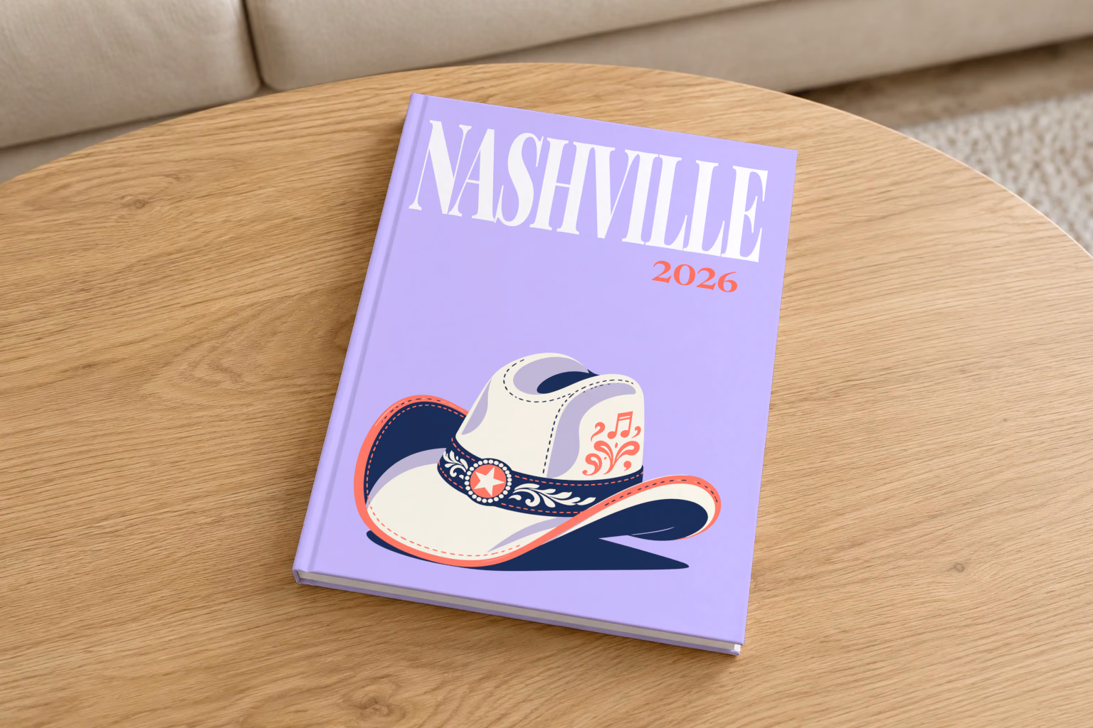 Tennessee hardcover photo book with the Nashville illustrated cover of a white cowboy hat with music notes on lavender, on a round oak coffee table in a bright living room