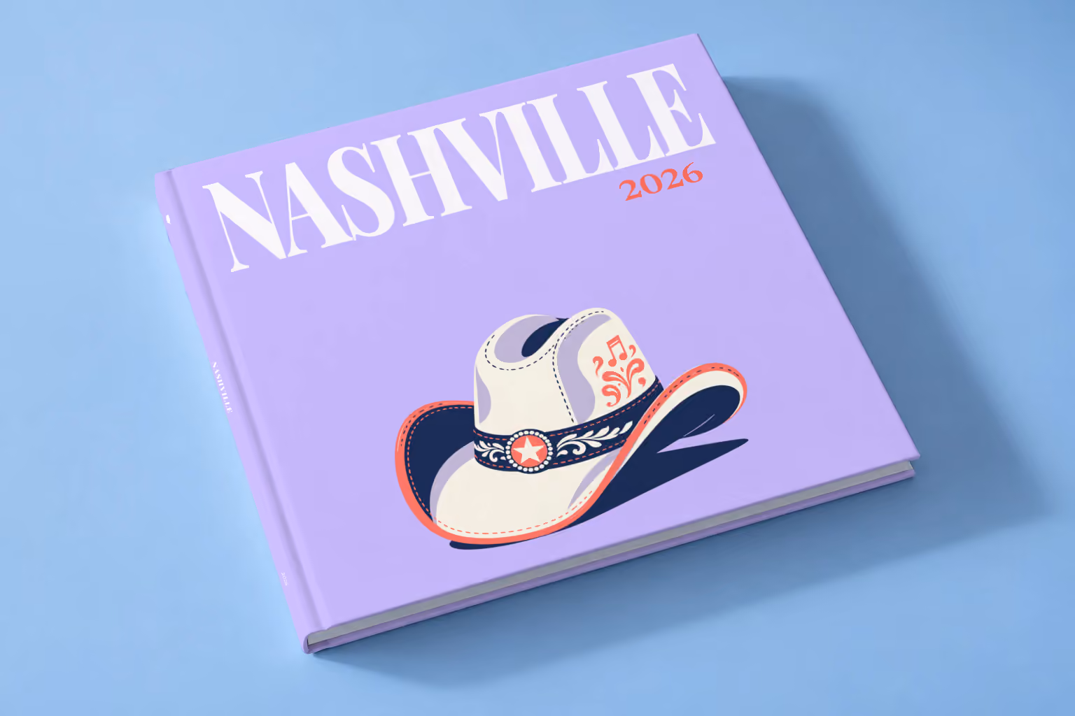 Tennessee square hardcover photo book with the Nashville illustrated cover of a white cowboy hat with music notes on lavender, lying on a pale blue studio backdrop