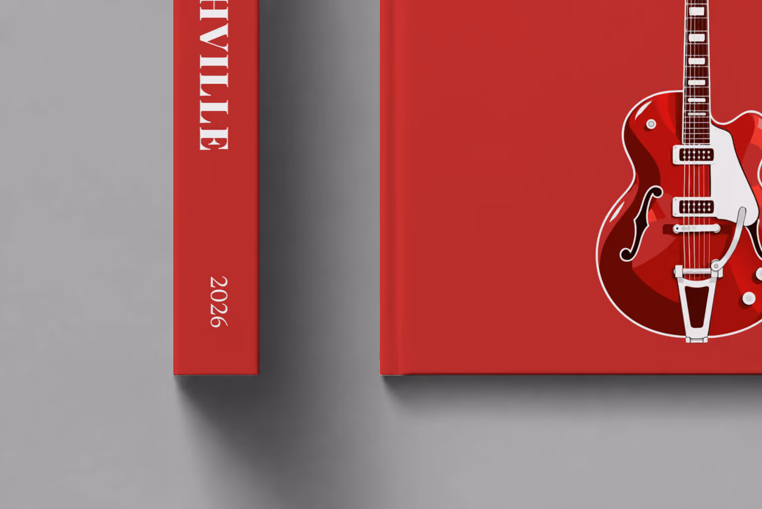 Tennessee hardcover photo book with the Nashville illustrated cover of a red electric guitar on crimson, shown close up beside its spine on a pale grey studio surface
