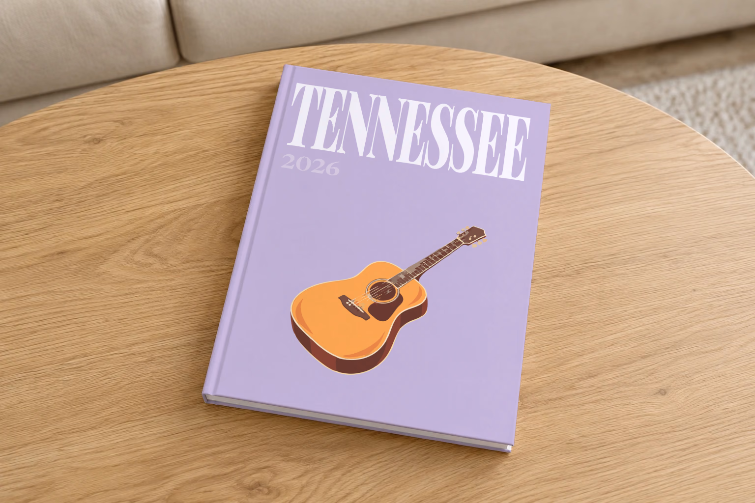 Tennessee hardcover photo book with the illustrated cover of an acoustic guitar on lilac, on a round oak coffee table in a bright living room