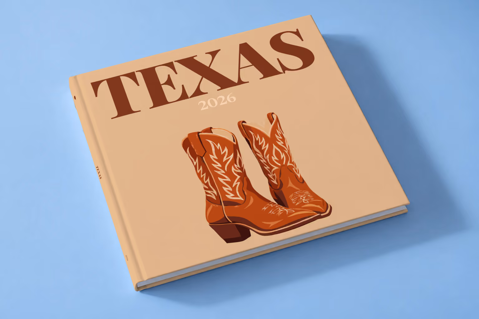 Texas square hardcover photo book with the illustrated cover of a pair of brown leather cowboy boots on tan, lying on a pale blue studio backdrop