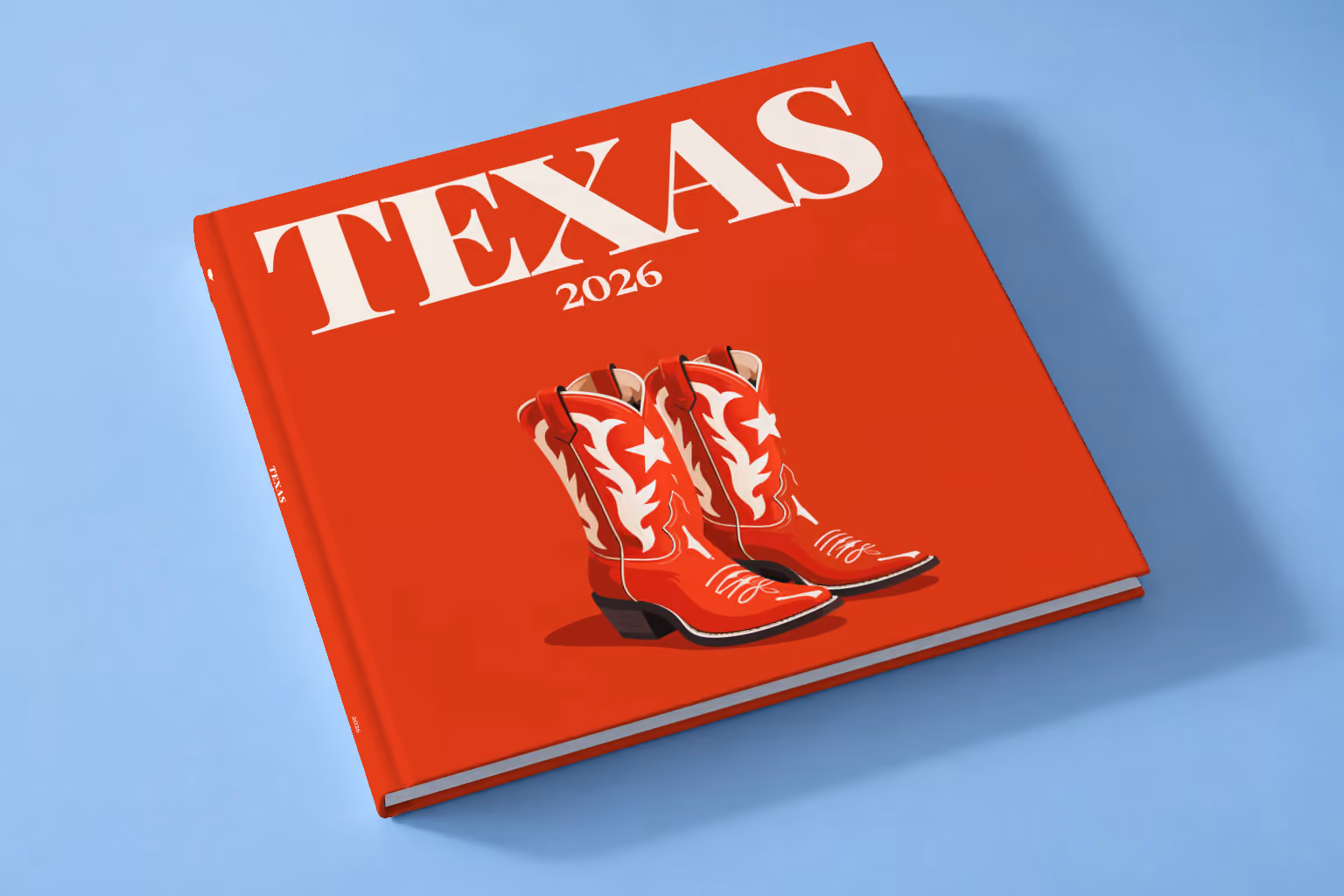 Texas square hardcover photo book with the illustrated cover of a pair of red cowboy boots with white stars on red, lying on a pale blue studio backdrop