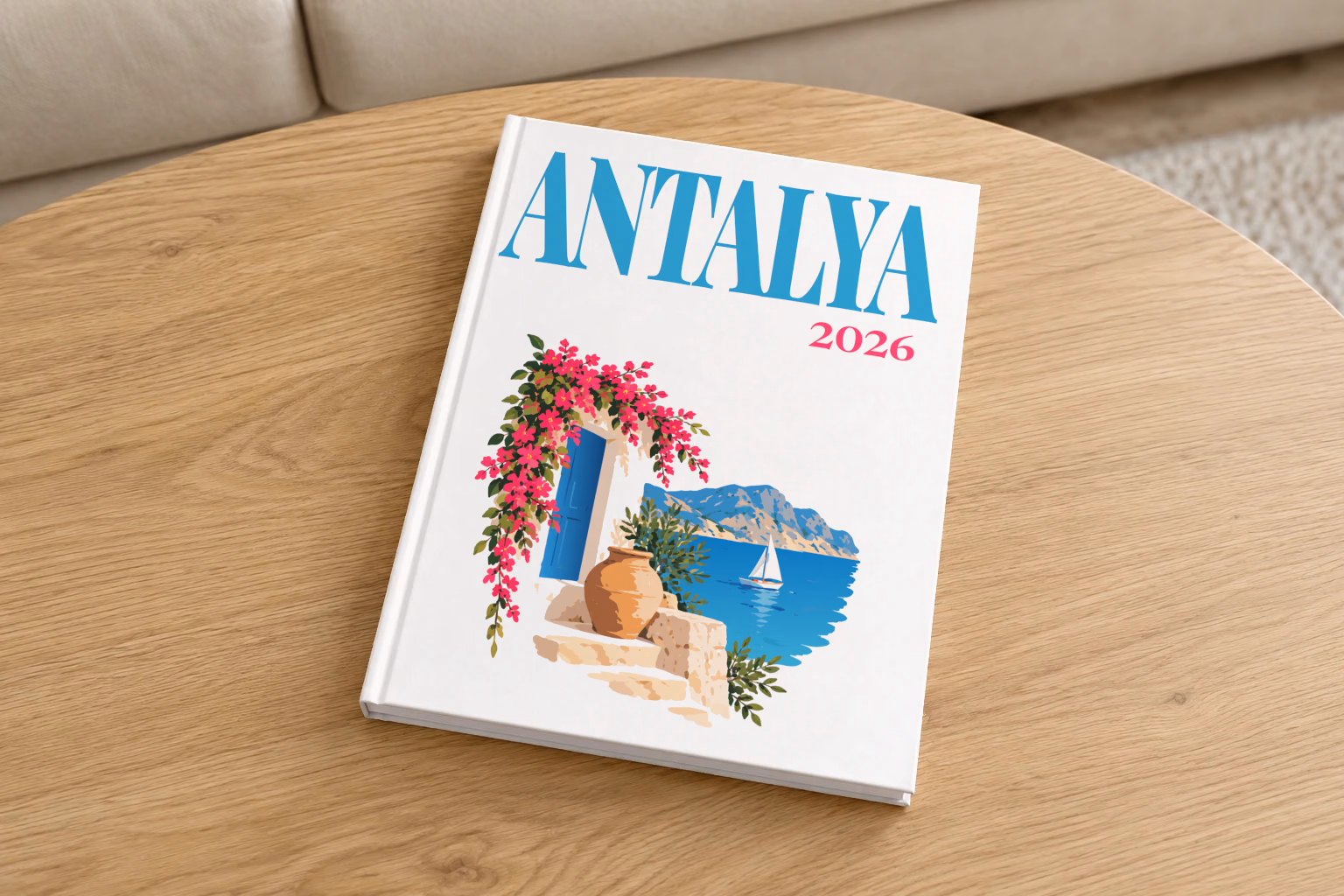 Turkey hardcover photo book with the Antalya illustrated cover of a blue door draped in pink bougainvillea above the Antalya coast on white, on a round oak coffee table in a bright living room