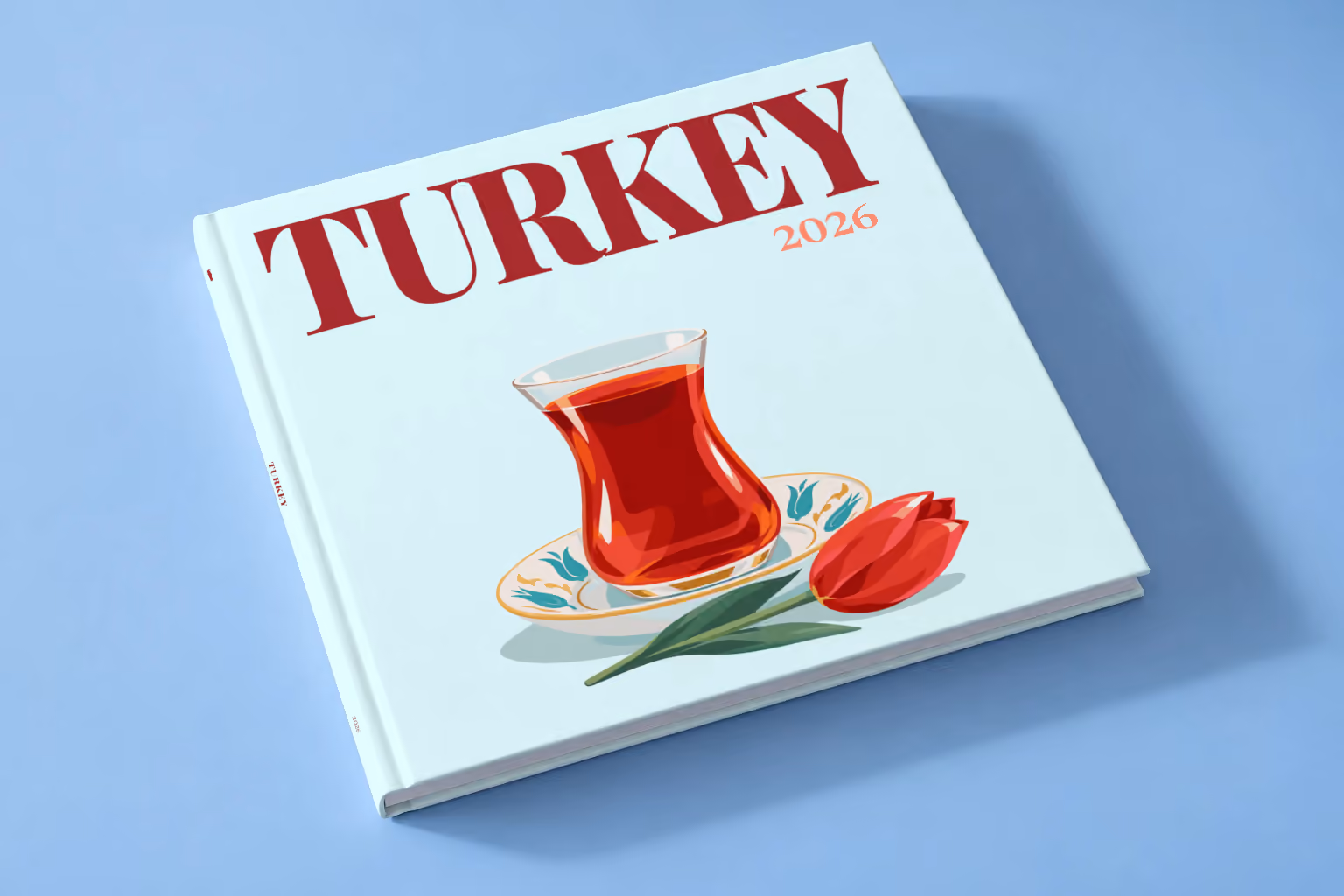 Turkey square hardcover photo book with the illustrated cover of a tulip glass of Turkish tea on a saucer with a red tulip on pale aqua, lying on a pale blue studio backdrop
