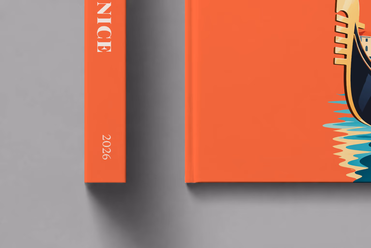 Venice hardcover photo book with the illustrated cover of a gondola, a striped mooring pole and Santa Maria della Salute on red-orange, shown close up beside its spine on a pale grey studio surface
