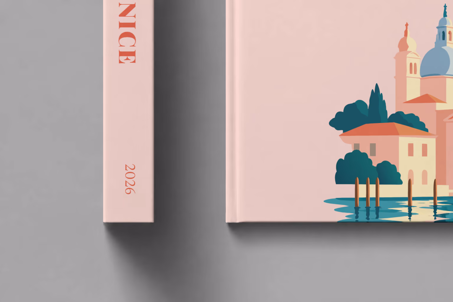Venice hardcover photo book with the illustrated cover of Santa Maria della Salute on blush pink, shown close up beside its spine on a pale grey studio surface