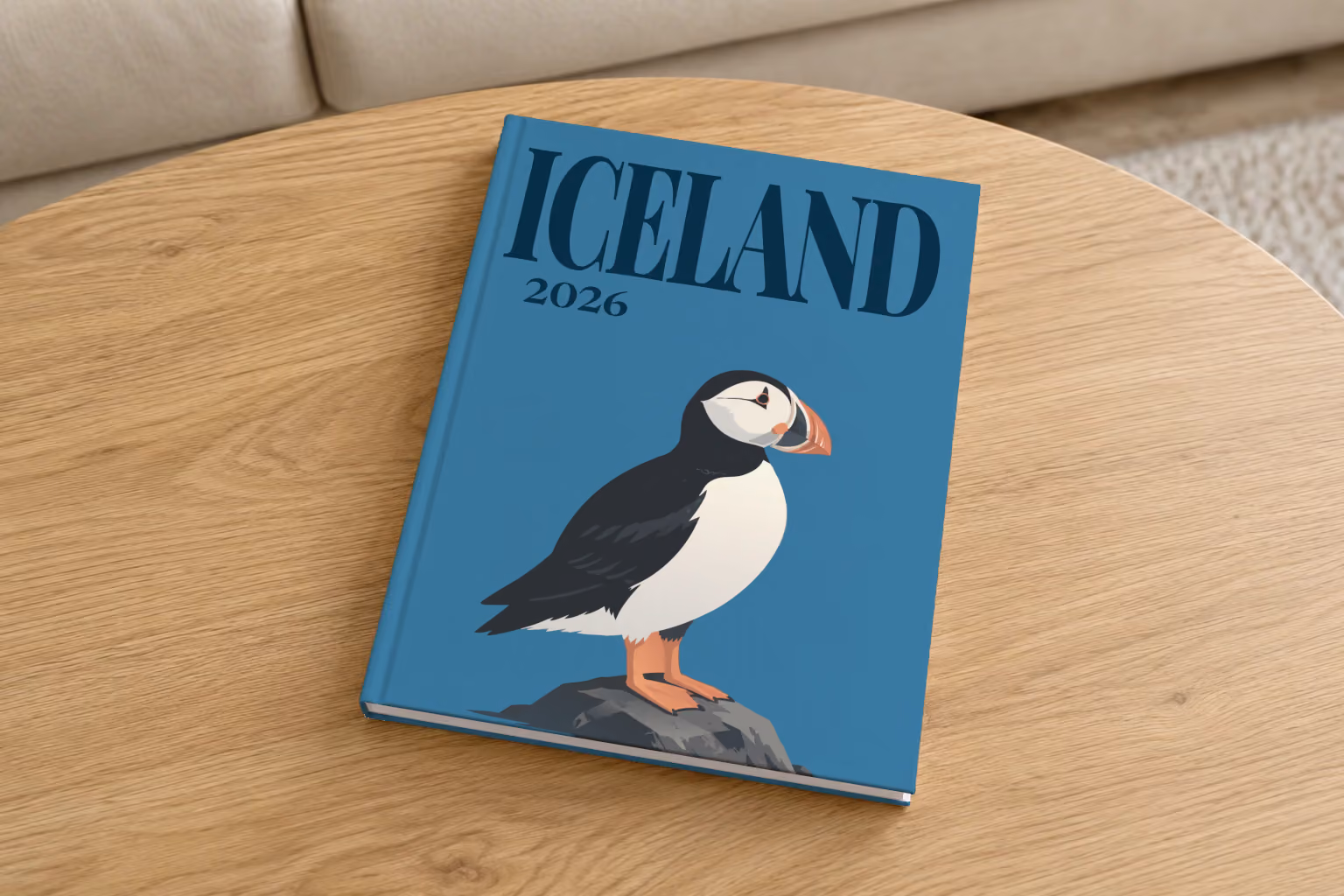 Iceland hardcover photo book with an illustrated cover of a puffin on a rock, on a round oak coffee table in a bright living room