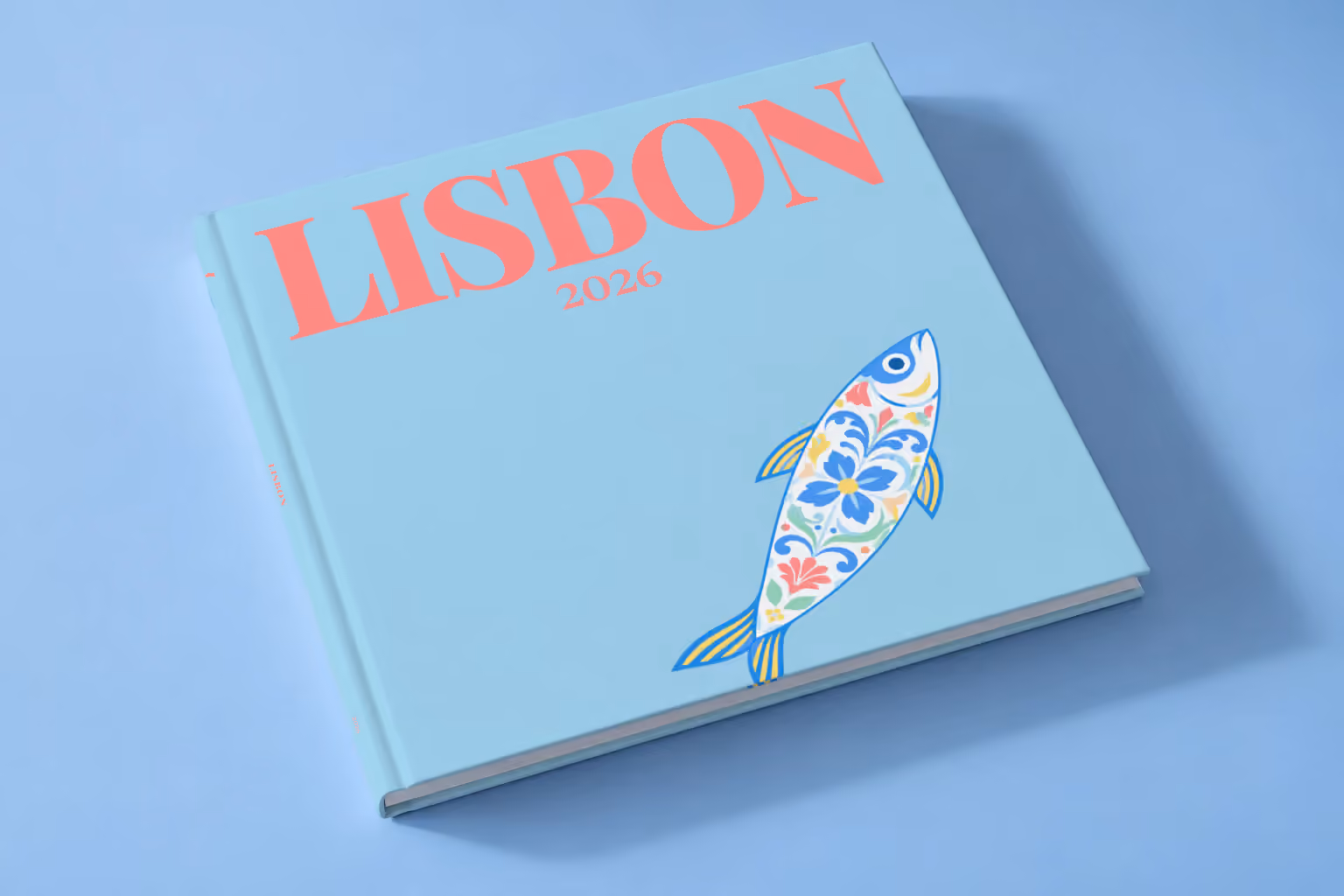 Lisbon hardcover photo book with an illustrated cover of a sardine painted like azulejo tiles, lying on a pale blue studio backdrop