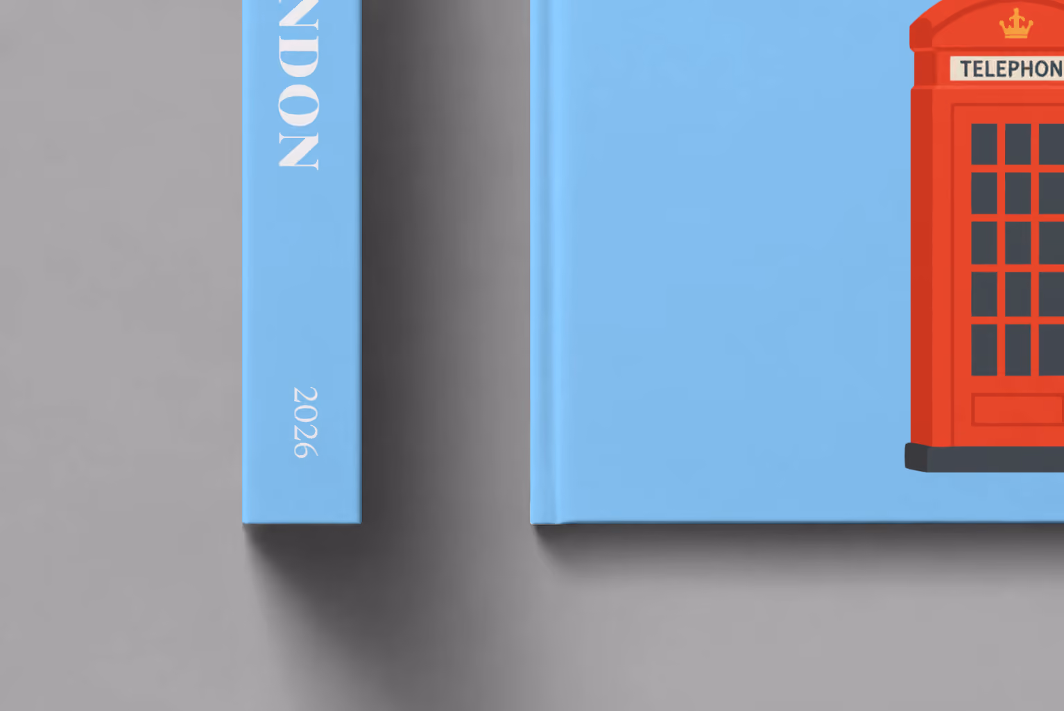 London hardcover photo book with an illustrated cover of a red telephone box, shown close up beside its spine on a pale grey studio surface