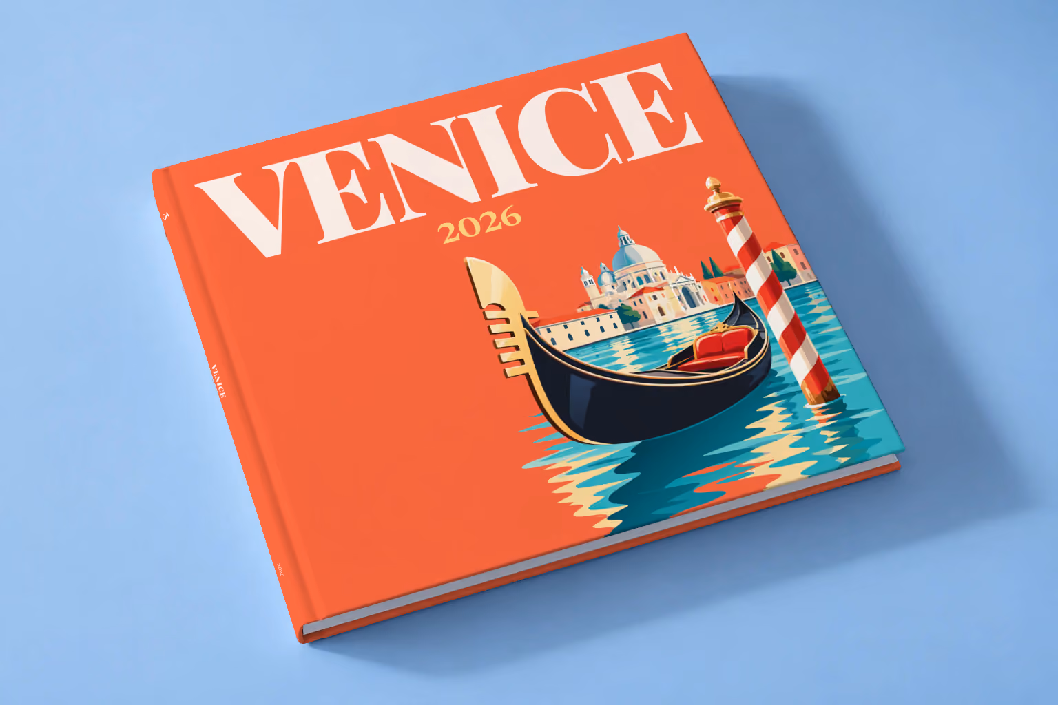 Venice hardcover photo book with an illustrated cover of a gondola, a striped mooring pole and Santa Maria della Salute, lying on a pale blue studio backdrop