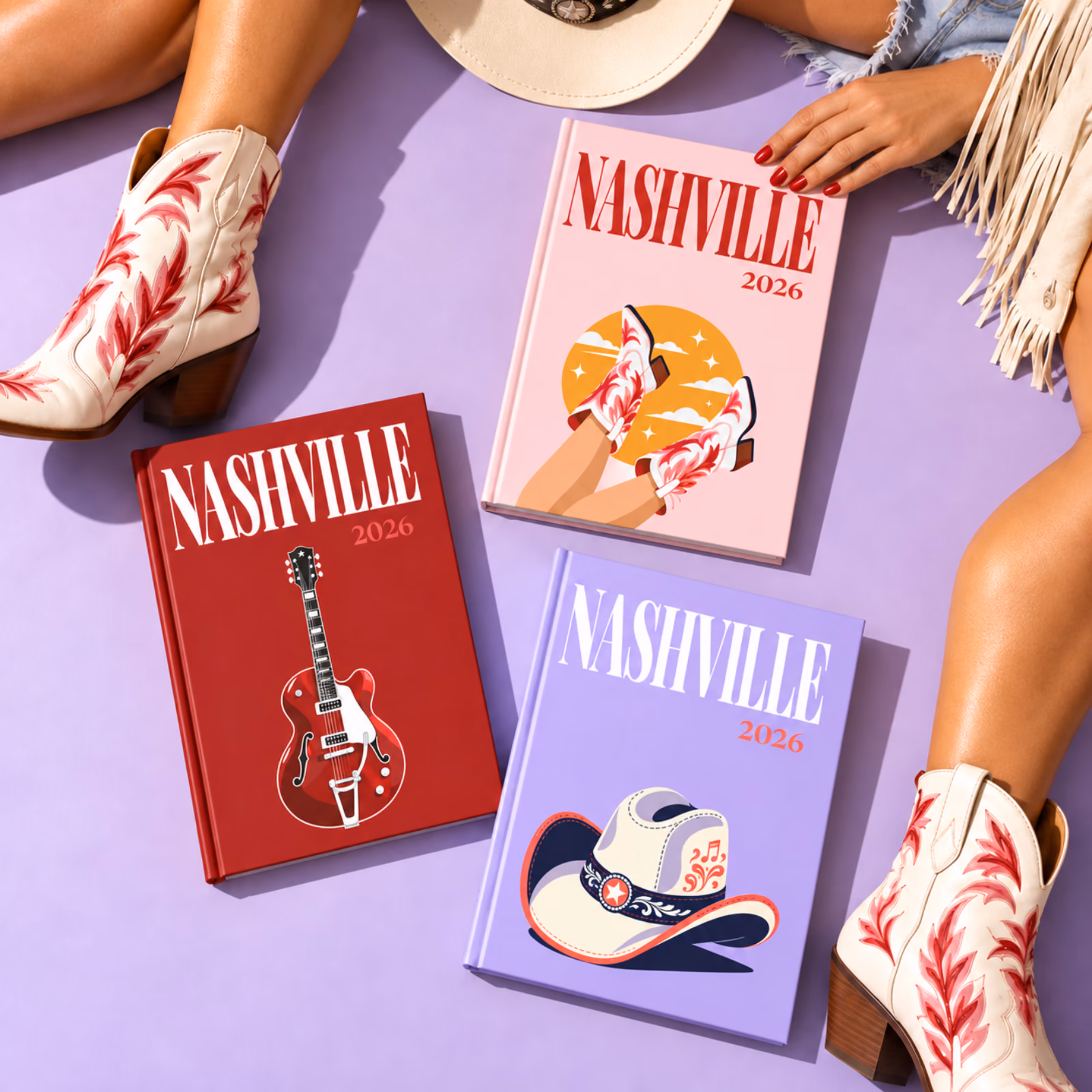 Three Nashville travel photo books with illustrated guitar, boot and cowboy hat covers, beside a pair of cowboy boots