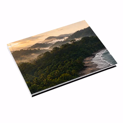 Closed landscape layflat photo book with a misty forested coastline printed across its cover