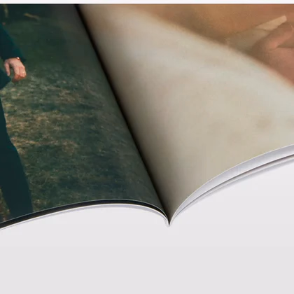 Close up of a softcover photo book's gloss page curving into the spine