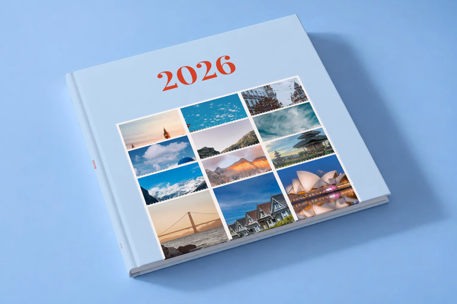 Stamps I year in review square hardcover photo book, a pale blue cover of travel photo stamps, lying on a pale blue studio backdrop