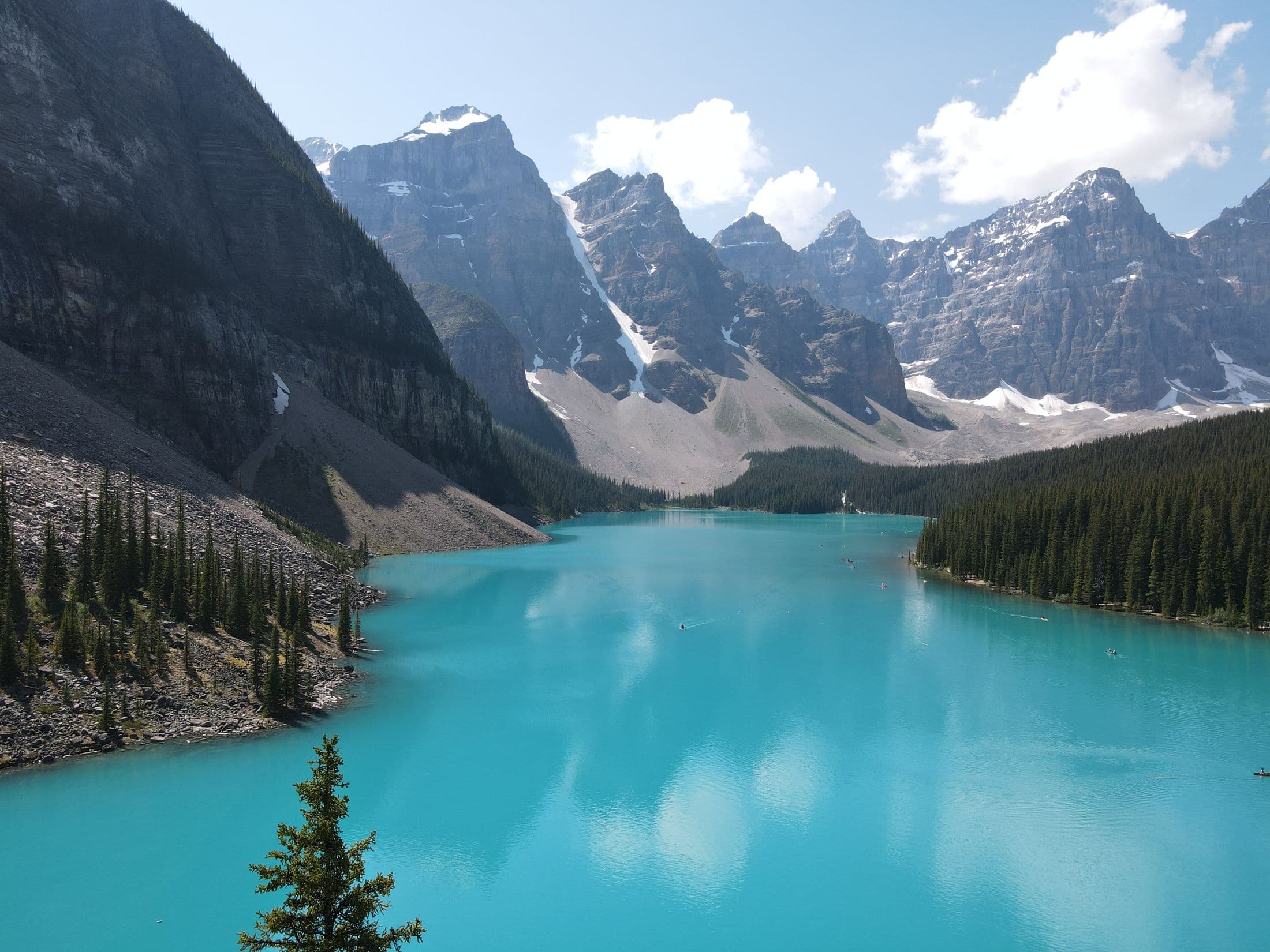Turquoise Moraine Lake surrounded by forest and the Valley of the Ten Peaks in summer