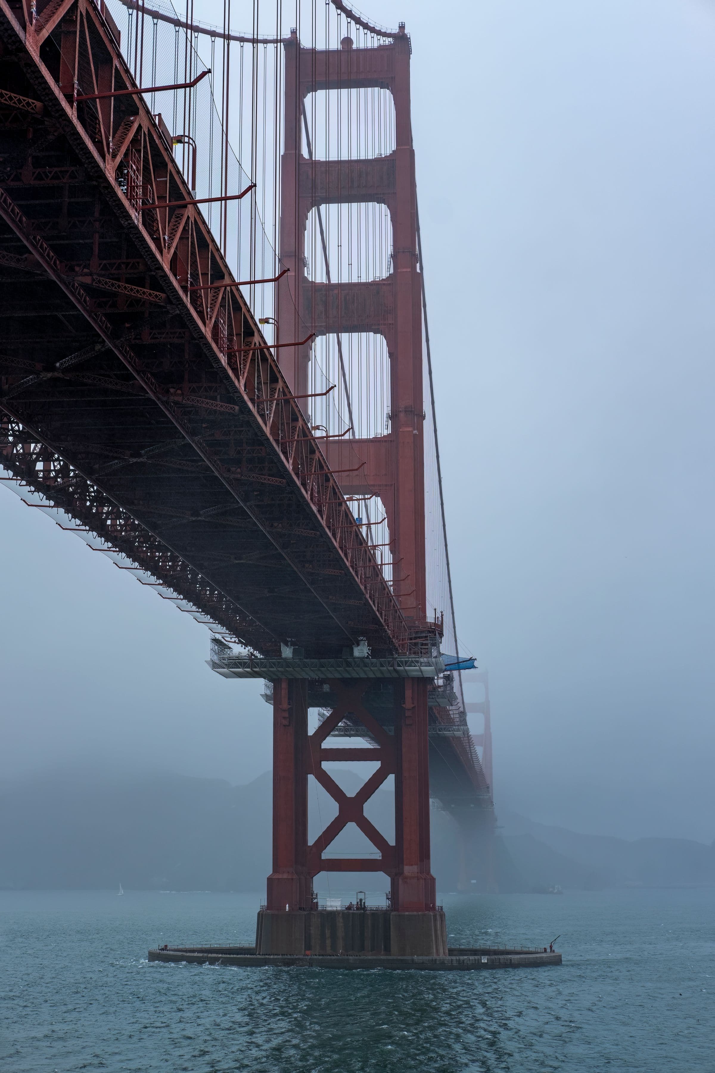 Golden Gate Bridge tower disappearing into dense coastal fog