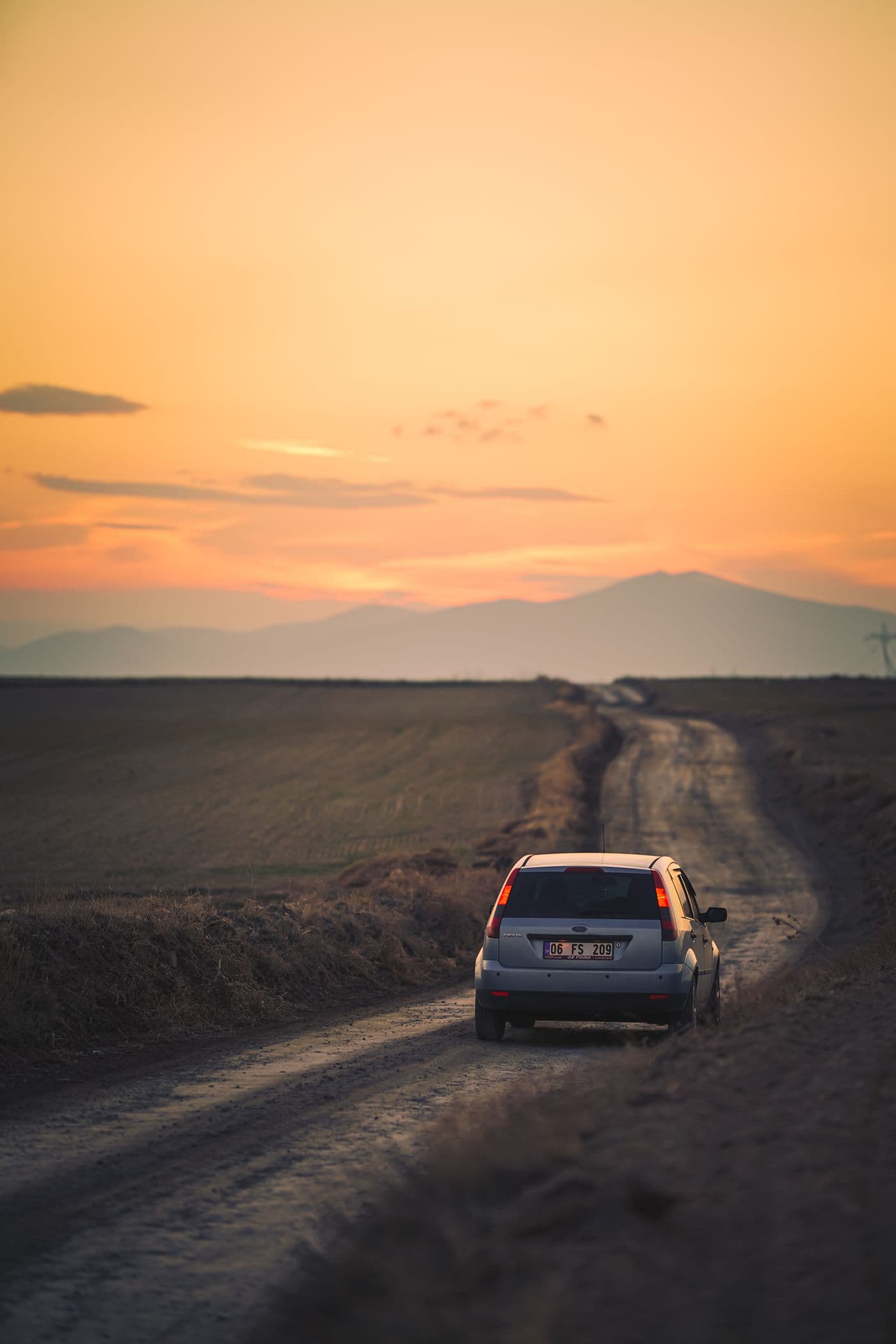 A car following a memorable backroad at golden hour