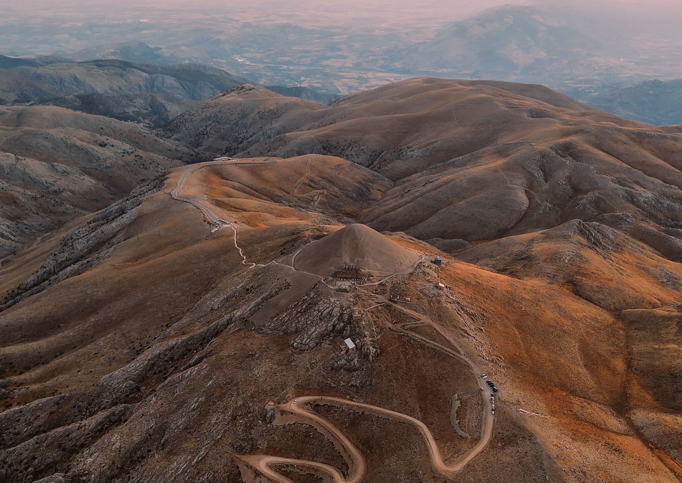 Aerial view of a winding road across a mountain landscape