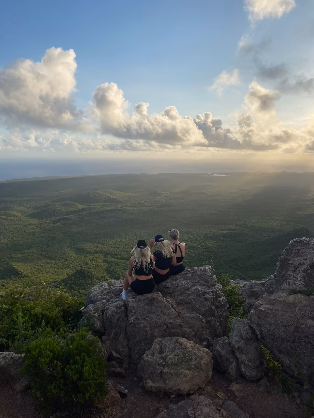 Three friends looking across a mountain landscape