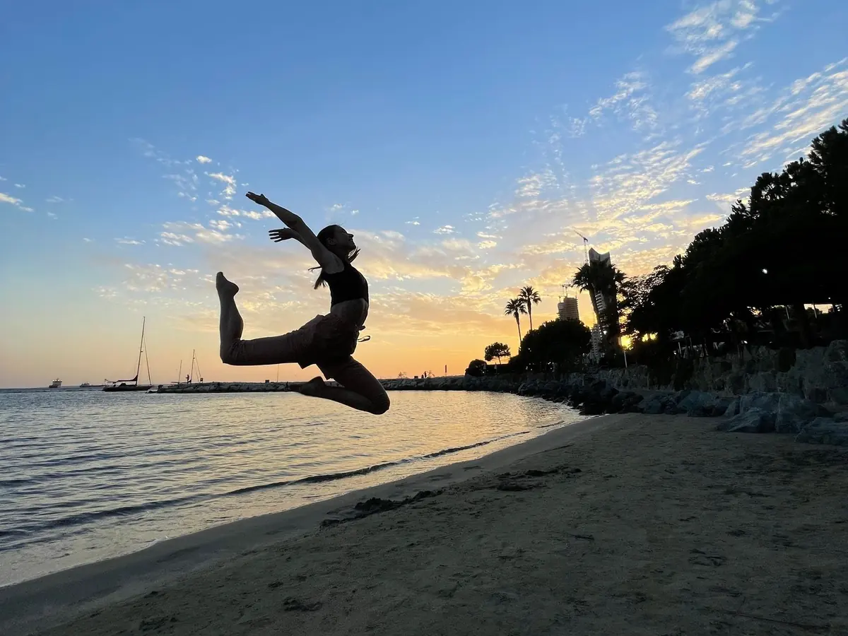 Traveller leaping above the shoreline at sunset