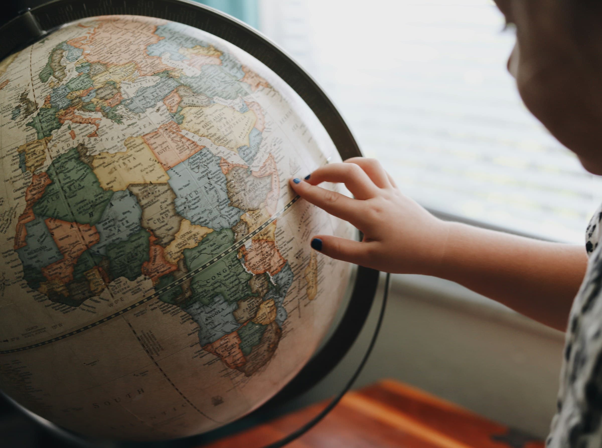 Traveller choosing a destination on a vintage globe