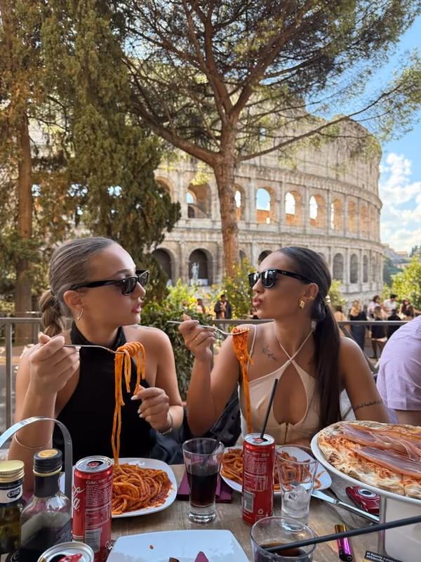 Friends enjoying pasta together on a weekend city break in Rome