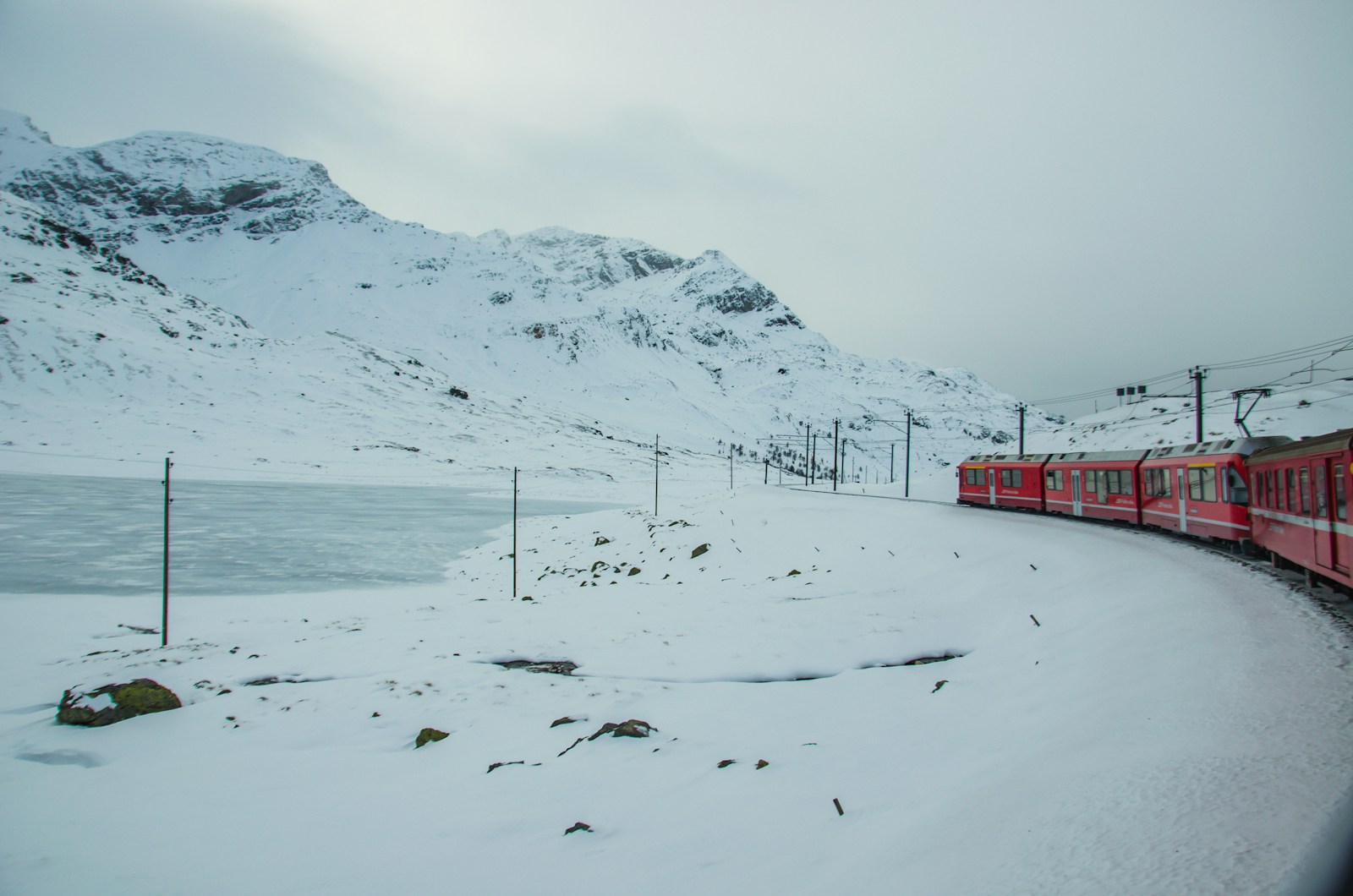 Bernina Express red train beside snowy Alpine peaks