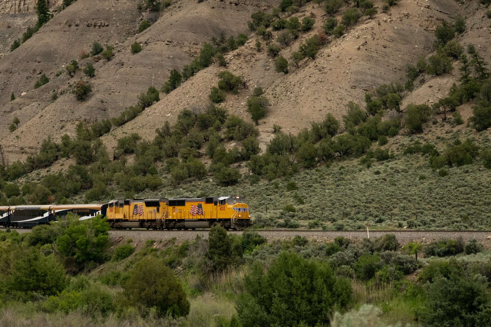 Long-distance train beside the Colorado River and mountain scenery